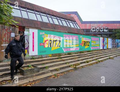 Berlin, Deutschland. Oktober 2024. Polizeibeamte verlassen einen Eingang zum Sport- und Erholungszentrum (SEZ) auf der Landsberger Allee. Nach einem langen Rechtsstreit um die SEZ ließ der Staat das Eigentum mit Unterstützung der Polizei räumen. Quelle: Soeren Stache/dpa/Alamy Live News Stockfoto