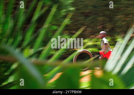 - Ein Junge, der in Kampala Uganda mit altem Reifen spielt Stockfoto