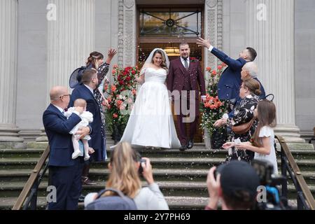 Konfetti wird über ein frisch verheiratetes Paar auf den Stufen des Old Marylebone Town Hall in London geworfen, das sein 100-jähriges Jubiläum mit 100 Hochzeiten an einem Tag feiert. Zu Ehren des Meilensteins werden 100 Paare den Knoten binden, eine Lebenspartnerschaft eingehen oder ihr Gelübde erneuern. Bilddatum: Dienstag, 1. Oktober 2024. Stockfoto