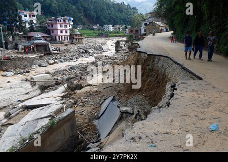 Lalitpur, Nepal. Oktober 2024. Nach den Überschwemmungen und Erdrutschen, bei denen mehr als 217 Menschen ums Leben kamen, laufen die Menschen an einer zerstörten Autobahn vorbei, wobei 28 weitere vermisste und noch nicht aufgezählte Menschen Tausende verdrängten, und sie haben in der Folge in Tikabhairab in Lalitpur, Nepal, am Dienstag, den 1. Oktober 2024, keinen Zugang zu Stromversorgung, Trinkwasser und an vielen Orten keine Verbindung. Quelle: ZUMA Press, Inc./Alamy Live News Stockfoto