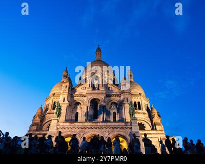 Touristenmassen und Einheimische auf den Stufen von Sacre Coeur, Nacht, Montmartre, Paris, Frankreich, Europa, EU. Stockfoto