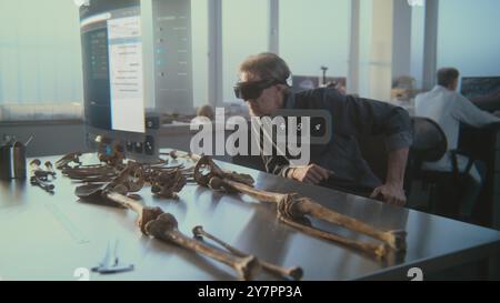 Fortgeschrittenes archäologisches Labor: Archäologe im VR-Headset untersucht altes Skelett mit Augmented Reality. VFX-Animation der holographischen Darstellung mit KI-gestütztem Assistenten und 3D-Modell des Neandertalers. Stockfoto