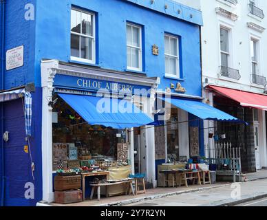 Farbenfrohe Geschäfte mit Tischen im Freien in der Portobello Road Stockfoto