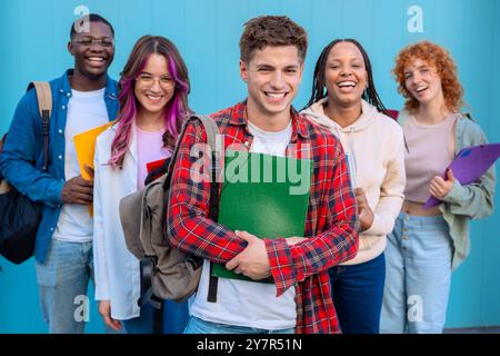 Gruppe lächelnder Schüler, die zusammen mit Rucksäcken und Büchern im Freien stehen Stockfoto