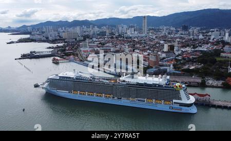 George Town, Penang, Malaysia - 25. Dezember 2023: Ein Kreuzfahrtschiff der Royal Caribbean wird im Kreuzfahrtterminal im Hintergrund des Penang Hill angedockt. Stockfoto