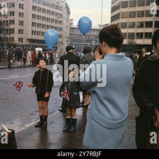 Eine Mutter fotografiert ihre Kinder bei der Straßenparade am Lord Mayor's Day in London, England, Großbritannien. Um die 1970er Jahre Stockfoto