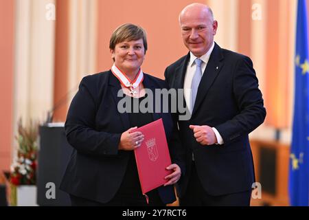 Berlin, Deutschland. Oktober 2024. Kai Wegner (CDU, r), Regierender Bürgermeister von Berlin, überreicht Eva Schumann, Geschäftsführerin der Opferhilfe Berlin, im Roten Rathaus den Verdienstkreuz des Landes Berlin. Quelle: Sebastian Gollnow/dpa/Alamy Live News Stockfoto