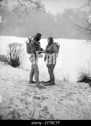 IN EIS EINGEBETTET. Jeden Sonntag taucht eine Gruppe von Enthusiasten in ihren Anzügen in die eiskalten Gewässer des Laughing Water Creek, Dartford, Kent. Aber heute, bevor sie schwimmen konnten, mussten sie das dicke Eis brechen. I.N.P. FOTOSHOWS. Miss Pauline M. Ady, 24 Jahre alt, aus Teddington, schwimmt in Apparaten Stockfoto