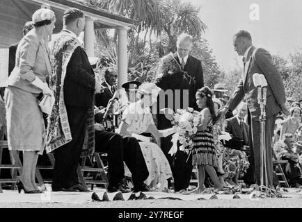 Blumen für die Königin in Neuseeland. Am 4. Januar 1954 überreicht die fünfjährige Maori-Tochter Anne PE Aurere Rogers ihrer Majestät der Königin während des königlichen Besuchs in Neuseeland einen Blumenstrauß vor dem historischen Waitangi-Haus. Fotos Von Internationalen Nachrichten. Stockfoto