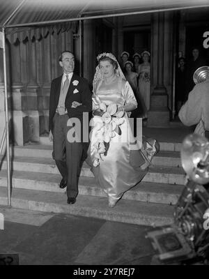 BRAUT & BRÄUTIGAM, DIE SICH 5.1.54 BEI Einer HOCHZEIT KENNENLERNTE, als Miss Aislinn Morris, ältere Tochter von Lord und Lady Morris, und Leutnant Angus J. C. Hildyard, von der Royal Artillery, heute Nachmittag in St. James's Church, Spanish Place, London heirateten, mussten sie an eine Hochzeit im Jahr 1937 gedacht haben, als sie sich zum ersten Mal trafen. Dann waren sie Pager und Brautjungfer und dieses Treffen begann ihre Freundschaft. Miss Morris ist jetzt 19 und Lieutenant Hildyard 25. I.N.P. Foto zeigt Lieutenant Hildyard sieht seine Braut an, als sie die Kirche nach ihrer eigenen Hochzeit heute Nachmittag verlassen. Bild von Joe Waddorf PJ/73651 Int Stockfoto