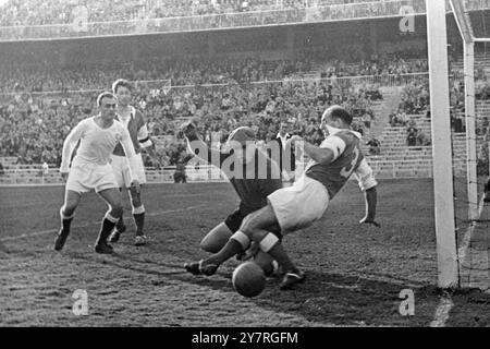 Die Madrider Fußballmannschaft schlägt die französischen champions. 24.11.53. Real Madrid schlug vor einigen Tagen den französischen Meister Reims 3-2 im Chamartin-Stadion in Madrid. 65.000 Zuschauer schauten sich das Spiel an, in dem die französische Mannschaft guten Stil zeigte, aber von den Spaniern übertroffen wurde. Das INP-Foto zeigt, wie der französische Torhüter Sinibaldi und der Linksverteidiger Marche den Ball um eine Kurve aus dem Tor schlagen, beobachtet von Madrids Mittelstürmer Alfredo Di Stefano (Argentinier) und dem Franzosen Jonquet. 7/PJ/72774. Fotos Von Internationalen Nachrichten. Stockfoto
