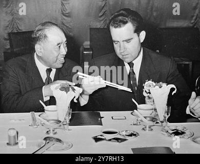 US-Vizepräsident verwendet Essstäbchen. Am 11. Dezember 1953 kam der US-Vizepräsident Richard M. Nixon letzte Woche aus Indochina in Hongkong an. Er wurde von seiner Frau begleitet. Ein INP-Foto zeigt, wie der Vizepräsident (rechts) bei einem chinesischen Bankett eine Lektion im Umgang mit Essstäbchen von U. Tat Chee, O.B.E., stellvertretender Vorsitzender der Herstellergewerkschaft, erhält. Fotos Von Internationalen Nachrichten. Stockfoto