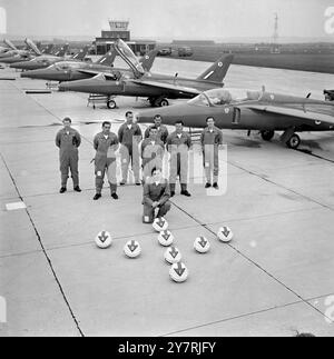 HALF-SWAN-FORMATION FÜR RED ARROWSLittle Rissington, Gloucestershire, England, Großbritannien : in Half-Swan-Formation wird das erste RAF-Kunstflugteam für 1965 von Nignat-Flugzeugen des RAF Flying Training Command gezeigt. Im Vordergrund kniet Flight Lieutenant Lee Jones, 37, Teamleiter, der letztes Jahr das RAF-Mignat-Kunstflugteam aus Valley leitete. Die rot bemalten Gnaten mit Rauch werden während der Saison auf vielen Flugshows im in- und Ausland erscheinen. Ihre erste öffentliche Ausstellung in Großbritannien wird auf der Biggin Hill International Air Fair vom 15. Bis 16. Dieses Monats stattfinden Stockfoto