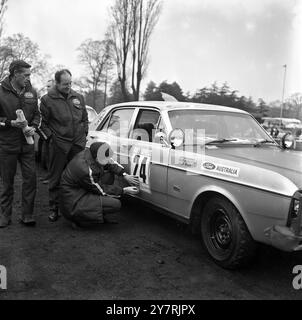 FINALE PREPARATIONSLondon, England, Großbritannien: Ian Vaughan, erster Fahrer des Ford Falcon GT, der bei der Rennveranstaltung London - Sydney Marathon in Australien teilnahm, fixiert heute die Rennnummer seines Autos im Crystal Palace, da die letzten Vorbereitungen für den morgigen Start des anstrengenden Events im Gange waren. Sehen Sie die Beifahrer Jack Ellis (links) und Bob Forsyth. Hundert Autos aus 16 Nationen und mehr als 260 Fahrer – Männer und Frauen – nehmen am 10000-km-Rennen Teil. 23. November 1968 Stockfoto