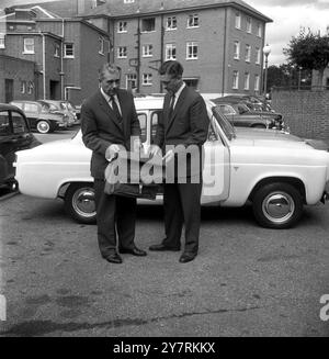 DIE POLIZEI UNTERSUCHT DEN INHALT DES BANDITEN VEHICLESBournemouth, Hants, England, UK: Detective Superintendent Ben Ballard (links) und Detective Chief Inspector Fred Tilling von Bournemouth Police halten Fanggeräte, die sie im weißen Anglia-Auto (Hintergrund) eines der Fahrzeuge gefunden haben, die im Zusammenhang mit dem großen Zug-Raub verwendet wurden. Hinter der Anglia befindet sich ein Austin A35 Van, in dem die Polizei £50.000 fand, die vermutlich Teil der £2.500.000-Beförderung von dem Angriff auf das Glasgow-Euston-Reisepostamt in Cheddington, Buckinghamshire, waren. Der Van enthielt auch ein Angelnetz. Und Weiter Stockfoto