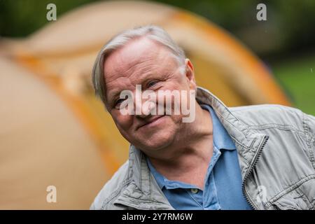 PRODUKTION - 01. Oktober 2024, Nordrhein-Westfalen, Münster: Axel Prahl (Oberinspektor Frank Thiel), Schauspieler, steht zwischen Zelten im Park hinter der Burg am Set des Münsterer Tatorts. Die neue Episode „Ich gestehe“ (AT) befasst sich mit dem Wohnungsmangel bei Studenten. Foto: Rolf Vennenbernd/dpa Stockfoto