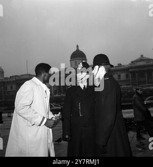 SCHWERGEWICHT HILTON IN LONDONLondon, England, Großbritannien : auf dem Bild mit zwei Polizisten auf dem Londoner Trafalgar Square ist der US-Schwergewichtboxer Hubert Hilton, der am 25. Januar in Olympia gegen Henry Cooper kämpft. 20. Januar 1966 Stockfoto