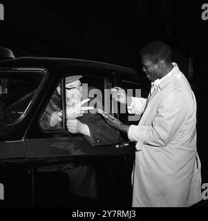 SCHWERGEWICHT HILTON IN LONDONLondon, England, Großbritannien: Hier wird ihm die 2-Schilling-Münze von einem Londoner Taxifahrer erklärt, der am 25. Januar in Olympia gegen Britatin Henry Cooper kämpft. 20. Januar 1966 Stockfoto