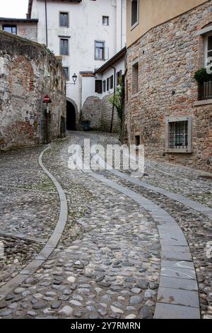 Die Formen einer geschwungenen Kopfsteinpflasterstraße in Cividale del Friuli, Friaul Julisch Venetien, Italien Stockfoto