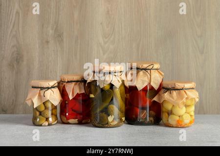 Verschiedene eingelegte Produkte in Gläsern auf grauem Tisch Stockfoto