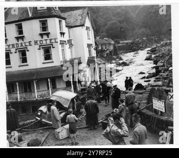 DIE POLIZEI EVAKUIERT OBDACHLOSE AUS DEM BETROFFENEN LYNMOUTH. West Lynmouth, North Devon: Polizei evakuiert Besucher und Obdachlose aus dieser Stadt in North Devon, die am stärksten von den Überschwemmungen nach großen Stürmen in North Devon und Somerset betroffen war. Häuser, Garagen, Autos und Nebengebäude wurden in Lynmouth weggefegt, als der Fluss Lyn, vom Regen geschwollen, den Kurs wechselte und durch die Stadt wütete. Brücken wurden abgerissen und riesige Felsbrocken vom rauschenden Wasser herumgeworfen. Der Tribut, der durch die Stürme verursacht wurde, wird angenommen, dass fünf Tote, 16 Vermisste und Hunderte Obdachlose sind. August 1952 Stockfoto