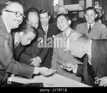 DER KRONPRINZ IST AMÜSANT 30.7.53 Kronprinz Akihito von Japan, der heute in Holland ist, besuchte die Diamantenwerke des Juweliers A. Asschor in Amsterdam. Foto zeigt, wie der japanische Botschafter in den Haag durch eine Lupe auf einen Diamanten blickt, lacht der normalerweise ernste Kronprinz (Mitte) mit Herzenslust über einen Witz. 30. Juli 1953 Stockfoto