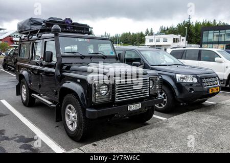 EGILSSTADIR, ISLAND - 3. JULI 2014: Zwei Land Rover Autos parkten und bereiteten sich auf eine Expedition in Island vor. Es gibt ein altes Modell Defender und modern Stockfoto