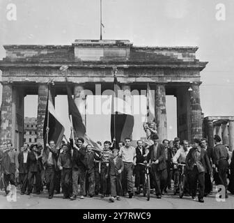 WESTDEUTSCHE FLAGGE IN OST-BERLIN 18.6.53 in OST-BERLIN wurde gestern nach weit verbreiteten Aufständen gegen die sowjetische Regierung das Kriegsrecht ausgerufen. Foto zeigt Demonstranten marschieren in die russische Zone Berlins mit der schwarzen, roten und goldenen Flagge der Bundesrepublik Deutschland, nachdem sie die rote Flagge am Brandenburger Tor niedergerissen und verbrannt haben. 18. Juni 1953 Stockfoto