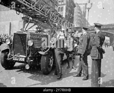 DIE MENSCHENMASSEN BEOBACHTEN, WIE die FIREOffice-Arbeiter IN DER STADT ihre Mittagspause einlegten, wie Feuerwehrmänner eine Flamme angriffen, die in einem Gebäude in der Farringdon Street, London, England, ausbrach. Fotoshows : die Polizei benutzt Walkie-Talkie-Funkgeräte am Brandort. 11. Mai 1953 Stockfoto