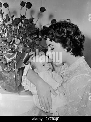 ELIZABETH TAYLOR WURDE ZUR MUTTER DES JAHRES GEWÄHLT Filmstar Elizabeth Taylor wurde von 3.800 amerikanischen Floristen zur Mutter des Jahres gewählt. Natürlich haben sie es mit Blumen gesagt und ihr einen Blumenstrauß mit American Beauty Roses verliehen. Fotoshows : „ Mutter des Jahres “ Elizabeth Taylor mit dem kleinen Sohn Michael Howard Wilding, der ihr geholfen hat, den Preis zu gewinnen, indem sie am 6. Januar dieses Jahres geboren wurde. Die Rosen, die mit dem Titel ausgezeichnet wurden, sind im Hintergrund zu sehen. 8. Mai 1953 Stockfoto