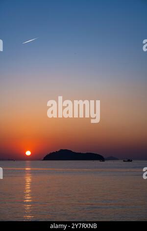 Ein atemberaubender Sonnenaufgang über Jamjindo Island, Incheon, Südkorea. Die Sonne steigt über dem Horizont auf und reflektiert über dem ruhigen Meer. Stockfoto