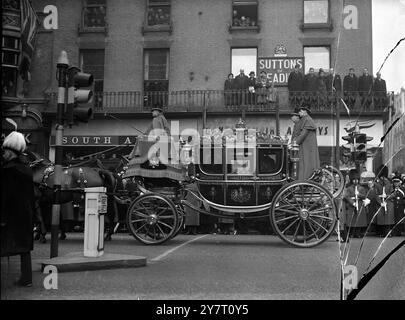 KINGS TRAUERPROZESSION VON WESTMINSTER HALL ZUR PADDINGTON STATION... 15.2.52 FOTO ZEIGT: Die Kutsche der Königin, in der sich die Königin, die Königin Mutter, Prinzessin Margaret und die Prinzessin Royal befanden, fährt Piccadilly herunter, beobachtet von vier Trauernden auf dem Balkon eines Gebäudes. Stockfoto