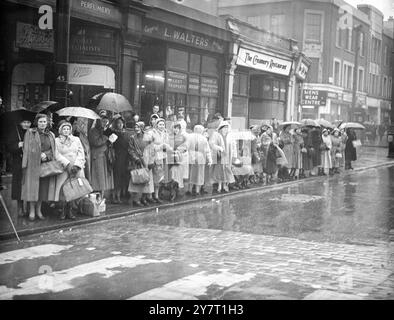 IN LONDON WARTEN SIE IM REGEN AUF KING's BEGRÄBNISPROZESSION 11-2-52 FOTOSHOWS :- Menschen in Makrelen und mit Regenschirmen, die im Regen vor der King's Cross Station warten, um die Begräbnisprozession von König George VI. Zu sehen Stockfoto