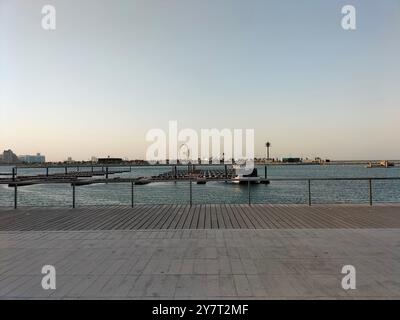 Dramatischer Himmel und ruhiges Wasser an der Lusail Corniche während Sonnenuntergang Stockfoto