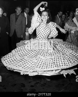 Lolitas Wirbel. Die Menschenmassen auf dem Bahnsteig der Victoria Station (London) waren Zeugen dieses Wirrlings von Polka-Dots, als Lolita Jimenez in ausgestellter spanischer Tracht, Spitzenunterrock und Castanetten in beiden Händen, einen traditionellen Tanz mit einer Kompanie anderer Tänzer aus Spanien demonstrierte, um am International Dance Festival in der Royal Festival Hall teilzunehmen. Der Tanz wird vom 2. September 1951 von der England Folk Dancing and Song Society gesponsert Stockfoto