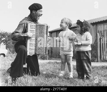 ROMA, BUSKER UND SCHAUSPIELER - FÜNFUNDVIERZIG JAHRE ALTER AL PURCHASE, SOHN DER KÖNIGIN DER LINCOLNSHIRE ROMA, DIE OFT IN DEN STRASSEN VON SOHO UNTERWEGS IST, WURDE FÜR DIE ROLLE VON ONKEL THEO IN DER PRODUKTION VON ENTEN UND LIEBENDEN, DIE NÄCHSTEN MONAT IM ARTS THEATRE ERÖFFNET WIRD, ANGEMELDET. AL WOHNT BEI ST. PAUL'S CRAY, KENT UND WIRD HIER GESEHEN, WIE ER ZWEI SEINER JUNGEN NACHBARN UNTERHÄLT - OBWOHL SEINE FARBENFROHE PERSÖNLICHKEIT SCHON BEI FRÜHEREN GELEGENHEITEN PRODUZENTEN ANGEZOGEN HAT. DIES IST DAS ERSTE MAL, DASS ER ZUSÄTZLICH ZU SEINER SONG-ROUTINE - 23. SEPTEMBER 1961 - AUFGEFORDERT WURDE, AUFZUTRETEN Stockfoto