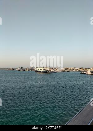 Ruhiges Meer und Sonnenuntergangsglühen an der Lusail Corniche Stockfoto