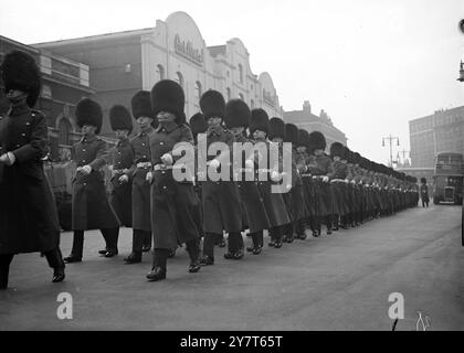 DIE IRISCHEN WACHPOSTEN MARSCHIEREN ZUR WESTMINSTER CATHEDRAL, vorbei an der Buckingham Palace Road, während sie von den Chelsea Barracks zur Westminster Cathedral in London marschierten, um heute an der Zeremonie teilzunehmen, bei der die alten Farben des 1. Bataillons des Regiments aufgestellt wurden. Die Farben werden in der Kathedrale aufbewahrt, bis sie in die Wachkapelle überführt werden können. 12. Dezember 1950 Stockfoto