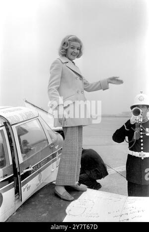 Miss Sheila Scott, die Solofliegerin, erhält einen musikalischen Gruß von zwei Buglern der Royal Marines School of Music, als sie heute auf ihre kleine Piper Comanche, Myth Too, am Flughafen London wartet, um den Schallplattenrekord für leichte Flugzeuge nach Nairobi zu erhalten. Sheila hält 77 Weltrekorde für leichte Flugzeuge und mehr als 50 große Auszeichnungen für ihre Leistung. 4. September 1969 Stockfoto