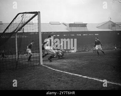 VIERTES TOR FÜR PORTSMOUTH BEI CHELSEA Scrimmage vor dem Chelsea-Tor, als der Ball den ausgestreckten Arm von Sid Bathgate (Nr. 2), Chelsea rechts hinten, überwindet und Portsmouth sein viertes Tor im Fußball-Liga-Spiel (erste Liga) in Stamford Bridge, London, heute (Boxing Day) gibt. Das Tor wurde von Reid, Portsmouth Mittelstürmer, erzielt – mit Harry Medhurst, dem Torhüter von Chelsea. Auf der linken Seite, in Tormund, ist Stan Willemse, Chelsea links hinten. 26. Dezember 1950 Stockfoto