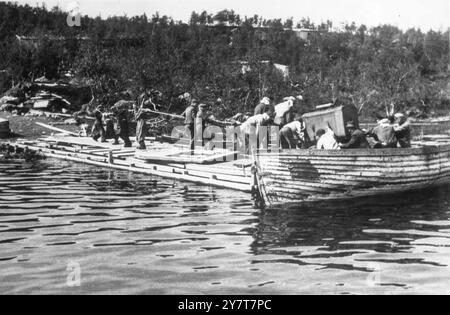 ZWANGSARBEIT IN norwegischen Gefangenen aus Konzentrationslagern der Nazis, die Ausrüstung in einem Fjord entladen, in Vorbereitung auf die Durchführung eines deutschen Zwangsarbeiterprojekts in Norwegen - 3. November 1943 Stockfoto