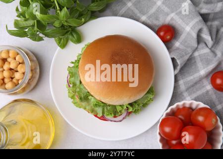 Köstlicher vegetarischer Burger mit Kichererbsenkotelett und Zutaten auf weißem Tisch, flach gelegt Stockfoto