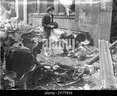 LONDONER ZIVILISTEN wurden DURCH FLIEGENDE BOMBZIVILISTEN GETÖTET und andere verletzt, als eine fliegende Bombe ein Gebäude in Aldwych, London, traf. Foto zeigt: Ein Offizier der R.A.F. untersucht eines der Opfer. 12. Juli 1944 Stockfoto