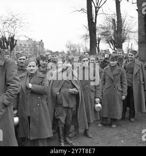 11. MÄRZ 1945Nearly 1.200 HUNGERNDE GEFANGENE wurden befreit, als die 7. US-Armee Stiring-Wendel südlich von Saarbrücken eroberte. Alle bis auf 200 bettseitige Männer gingen, krabbelten oder wurden in die amerikanischen Linien getragen, aber die ersten, die die Reise versuchten, wurden von zurückziehenden Deutschen erschossen. Diese Bilder wurden in einem Lager aufgenommen, wo sie gefüttert, medizinisch untersucht und registriert werden. Fotos zeigen: Einige der ausgemergelten Gefangenen, die vom 7. Befreit wurden. Armee; Eine Gruppe Jugoslawien unter den freigelassenen Gefangenen; sie stehen für ihre erste warme Mahlzeit für viele an Stockfoto