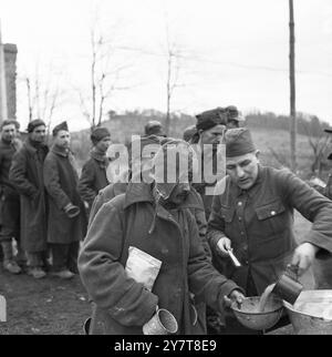 11. MÄRZ 1945Nearly 1.200 HUNGERNDE GEFANGENE wurden befreit, als die 7. US-Armee Stiring-Wendel südlich von Saarbrücken eroberte. Alle bis auf 200 bettseitige Männer gingen, krabbelten oder wurden in die amerikanischen Linien getragen, aber die ersten, die die Reise versuchten, wurden von zurückziehenden Deutschen erschossen. Diese Bilder wurden in einem Lager aufgenommen, wo sie gefüttert, medizinisch untersucht und registriert werden. Fotos zeigen: Einige der ausgemergelten Gefangenen, die vom 7. Befreit wurden. Armee, das sind Russen. Einer der Gefangenen serviert seinen hungrigen Kameraden im Aufnahmelager heiße Suppe Stockfoto