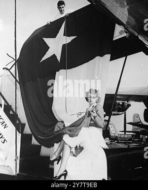 LONE STAR STATE SCHICKT Eine GROSSE FLAGGE , die die Länge der Flagge des Bundesstaates Texas überprüft - der " Lone Star State " - ist Pan American Airways Stewardess Elizabeth Macdonald aus Angleton , Texas . Korrekte Messung dieser Flagge des riesigen , stolzen und fast unabhängigen Staates ; 12 Fuß x 15 Meter . Szene ; La Guardia Field , New York . Die von der Dallas Historical Society gespendete Flagge wird neben der Union Jack beim ersten jährlichen Treffen der Männer der Royal Air Force in London, die ihre Flugausbildung in Terrell , Texas , erhalten , getragen . Die Flieger sind Texaner. Die Stockfoto