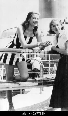 BEVOR SIE FAME New York USA KENNENLERNTE: Hollywood-Schauspielerin Grace Kelly (links), mit einer Bostoner Freundin Francis Gray, am 12. Juni 1951 auf dem Deck des amerikanischen Liners SS Constitution in New York, als sie mit dem Schiff auf einer 'Little Maiden Voyage' von Boston aus segelte. Während der Reise machte Mrs. Gray Schlagzeilen, als unfreiwilliger blinder Weg. Aber jetzt hat Grace, damals, und unbekanntes Modemodell, den Tisch gegen sie gedreht, indem sie erstens in Hollywood als preisgekrönter Star der Akademie berühmt wurde und zuletzt ihre bevorstehende Ehe mit dem souveränen Prinzen Rainier ankündigte Stockfoto