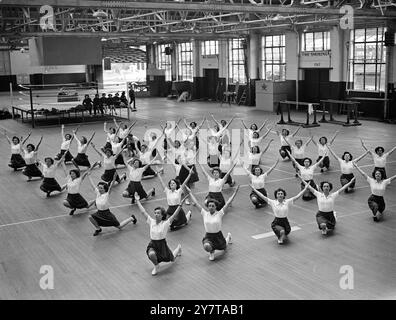 16. Mai 1950 Ein Team der Royal Air Force, bestehend aus einem Offizier, einem Flugoffizier Judy Wallis aus Ashbourne, Derbyshire, und 45 Flugfrauen, probt auf der Royal Air Force Station in Cosford, Shropshire, für das körperliche Training, an dem sie am diesjährigen Royal Tournament teilnehmen werden, das am 7. Juni in Earls Court in London eröffnet wird. Der Royal Naval Service der Frauen und das Royal Army Corps der Frauen nehmen ebenfalls an der Ausstellung Teil. Das Bild zeigt: Das WRAF-Team übt seine Royal Tournament-Ausstellung in der riesigen Turnhalle in der RAF Sta Stockfoto