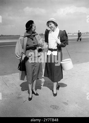 Am 1. Mai 1950 feiert Marcel Rochas sein 25-jähriges Bestehen als führender Pariser Couturier und präsentiert seine Sommer 1950 Kollektion bei zwei Mitternachtsparaden im Ciros Club, London, heute Abend und morgen Abend. Fünf eigens ausgewählte Schaufensterpuppen kamen heute (Montag) aus Paris an, um die Kollektion zu modellieren. Eine von ihnen, Barbara Smith, trug eines der ersten 1925 Modelle von Rocha zu Ehren des Designerjubiläums. Das Bild zeigt: Madame Helene Rochas (links), Ehefrau des Designers, trägt einen schwarz-weißen Pieds de Poules-Anzug mit schwerem Tweedmantel und grüßt Paris mann Stockfoto