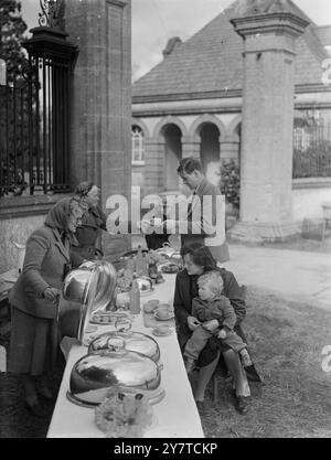 LADY LEES' SNACK Bar IST FÜR GESCHÄFTSLEUTE GEÖFFNET Eine Snackbar, die die formale würde eines großen Herrenhauses bietet, steht am Lodge Gate des Lytchett Minster (Poole, Dorset) und wartet auf die Begrüßung der Autofahrer auf dem Dorchester-Bournemouth Highway im Süden Englands. Und die Dame, die es leitet, ist in der Tat eine Dame: Lady Lees, Ehefrau des 3. Baronets, Sir John Victor Elliot Lees. Die Snackbar, in der hausgemachte Kuchen, Kekse, Würstchen und Brötchen, Sandwiches und Tee serviert werden, wird von Lady Lees, ihrer Schwiegertochter, Mrs. Faith Lees und ihrer Sekretärin besetzt. Die Gäste essen ihre Snacks von der alten Familie Stockfoto